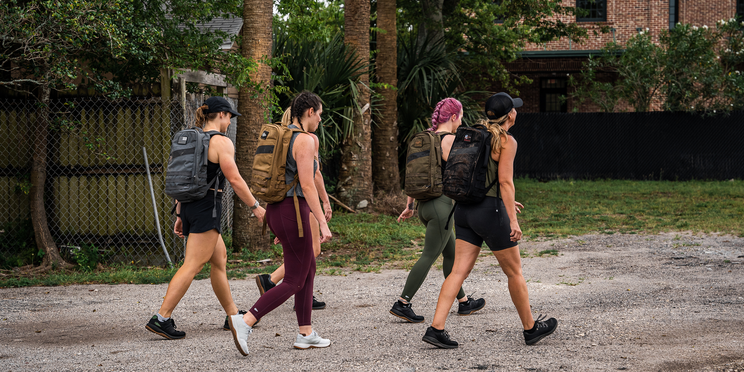 Group of women rucking outdoors wearing GORUCK backpacks and athletic gear