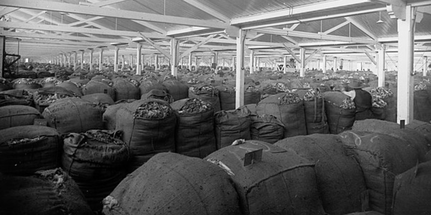 Historic warehouse filled with large wool bales, supporting GORUCK merino gear quality.