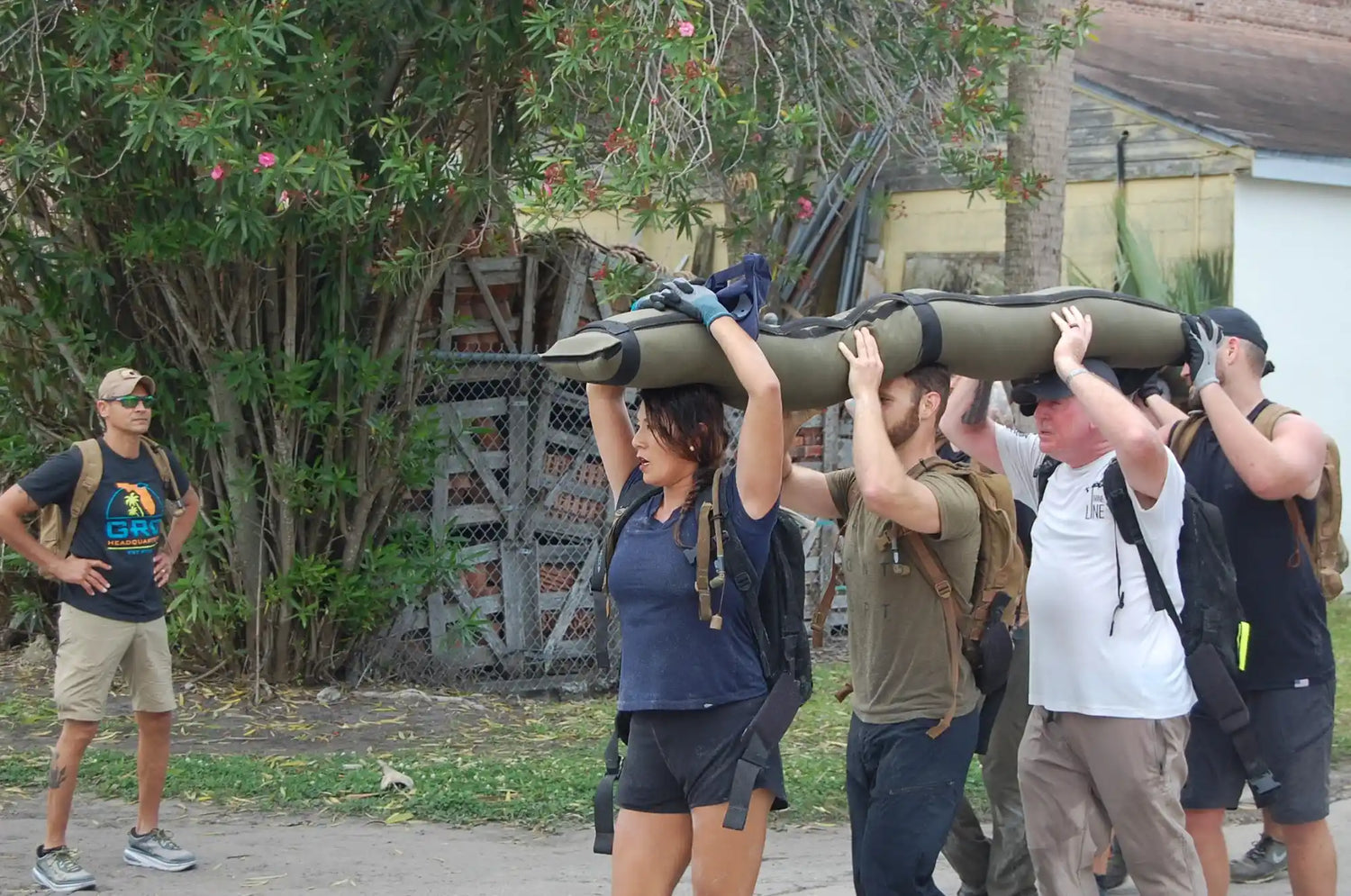 Group of people rucking outdoors with weighted gear during GORUCK team training event