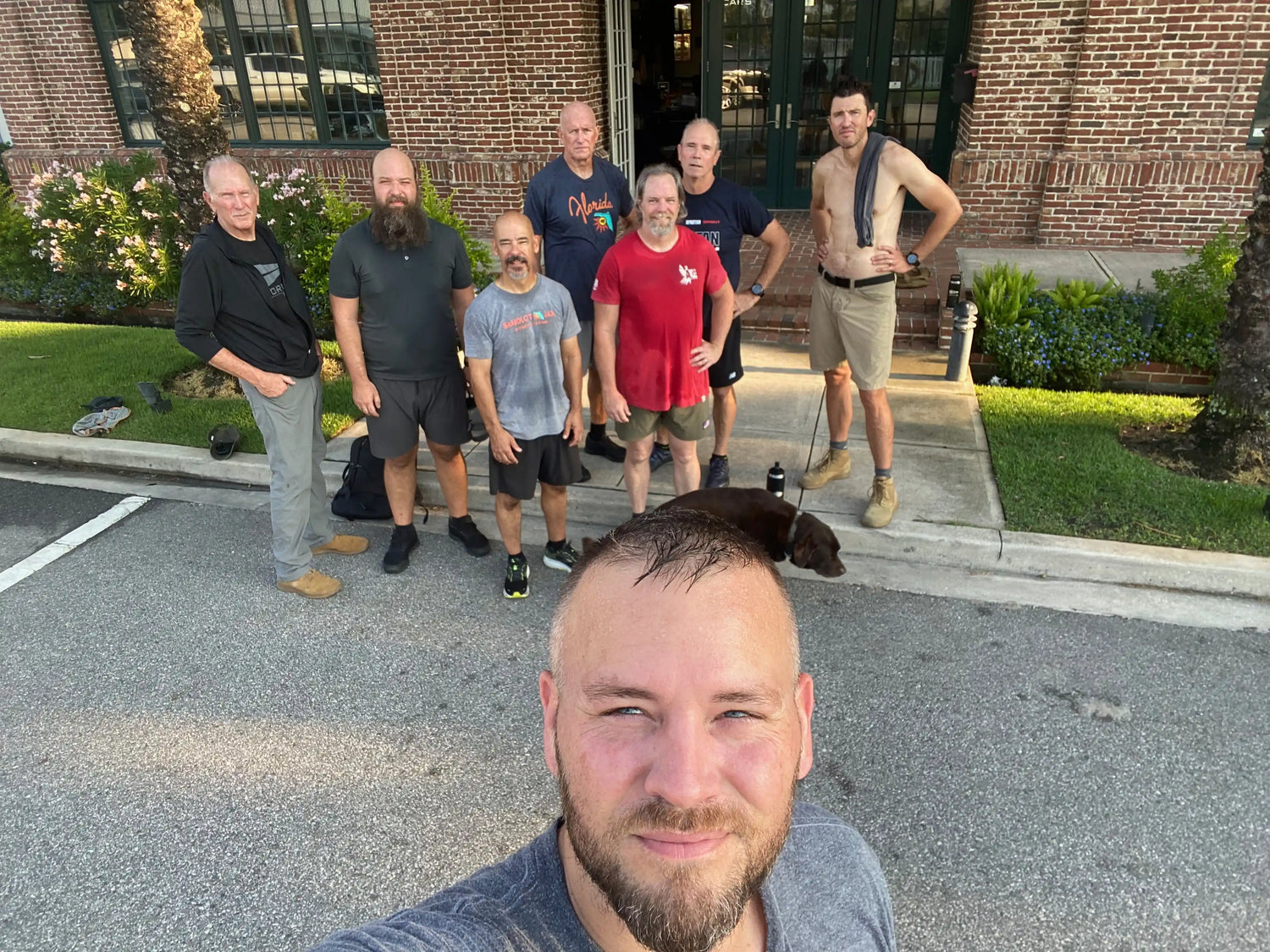 Group of men after a GORUCK rucking event outdoors in front of a brick building