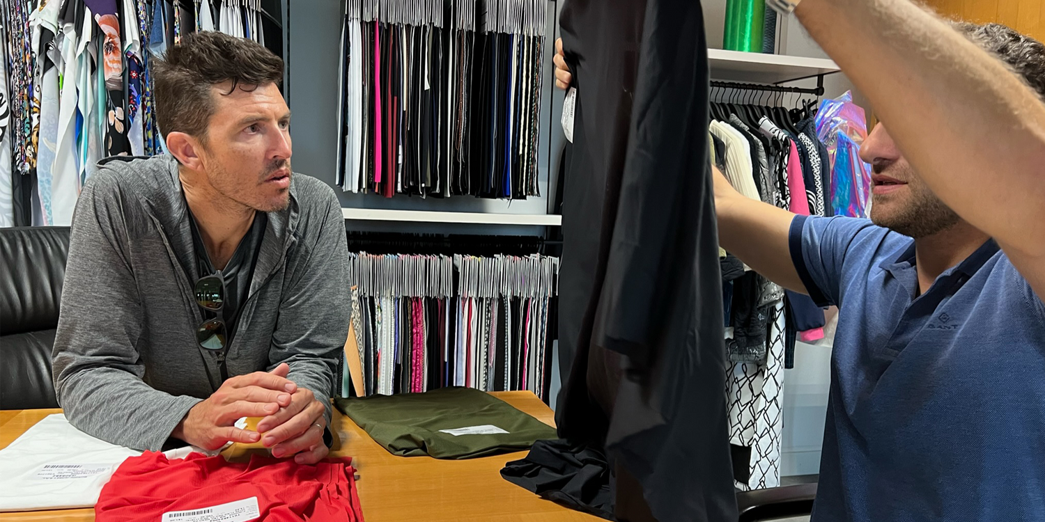 Two men review rucking gear fabric samples at a table in GORUCK design studio