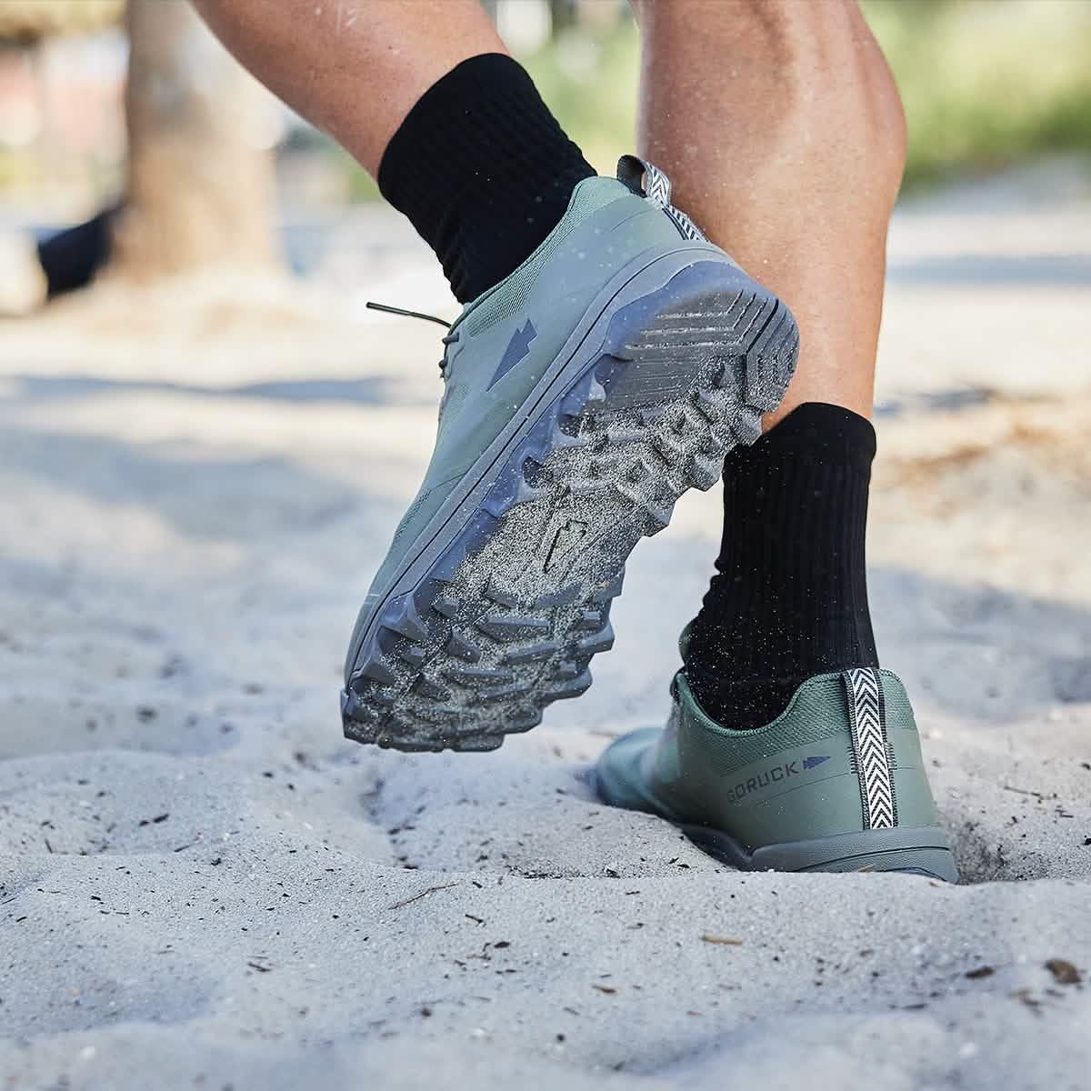 GORUCK trail running shoes on sand, rugged sole, person active outdoors