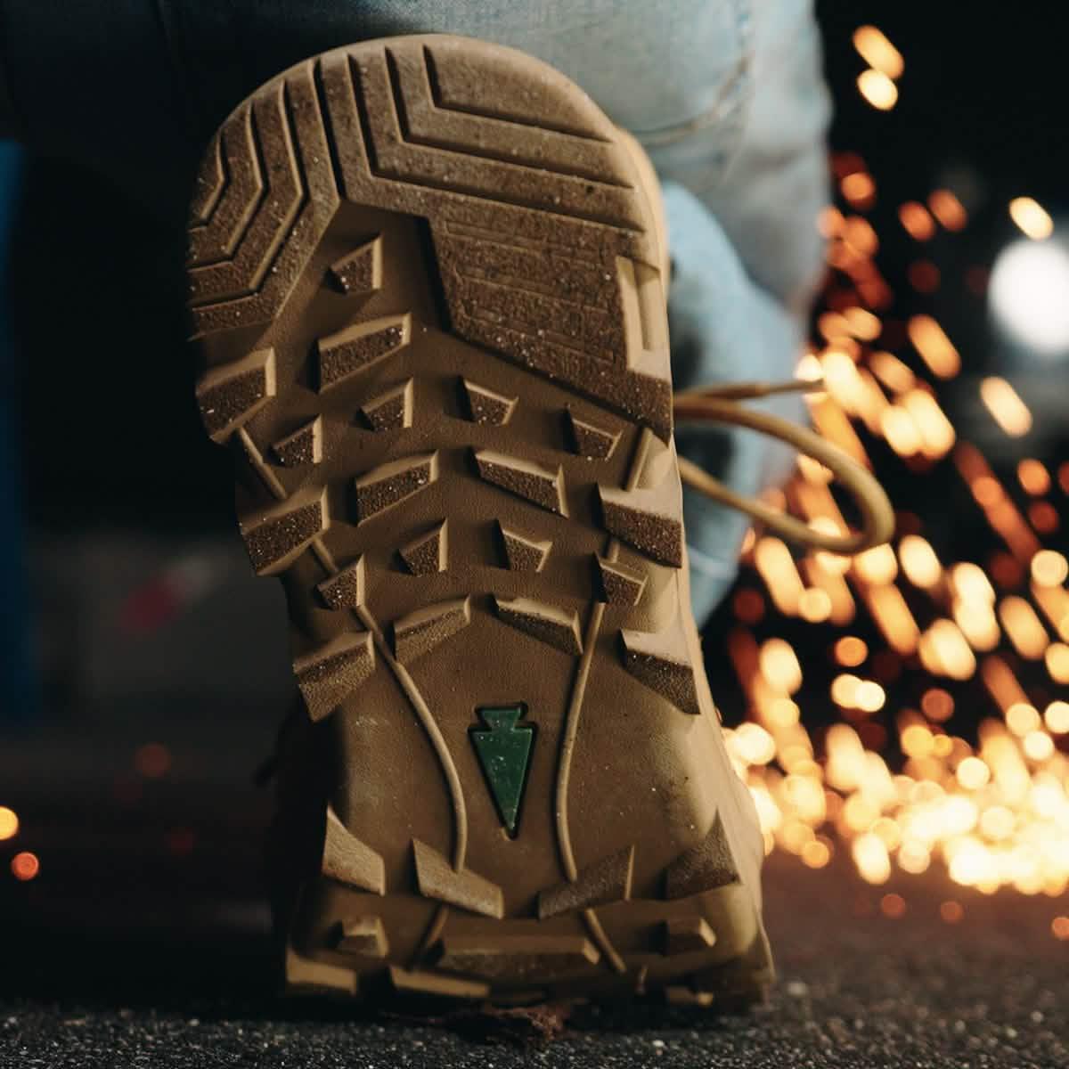 Close-up of GORUCK boot outsole with rugged tread, sparks flying in background