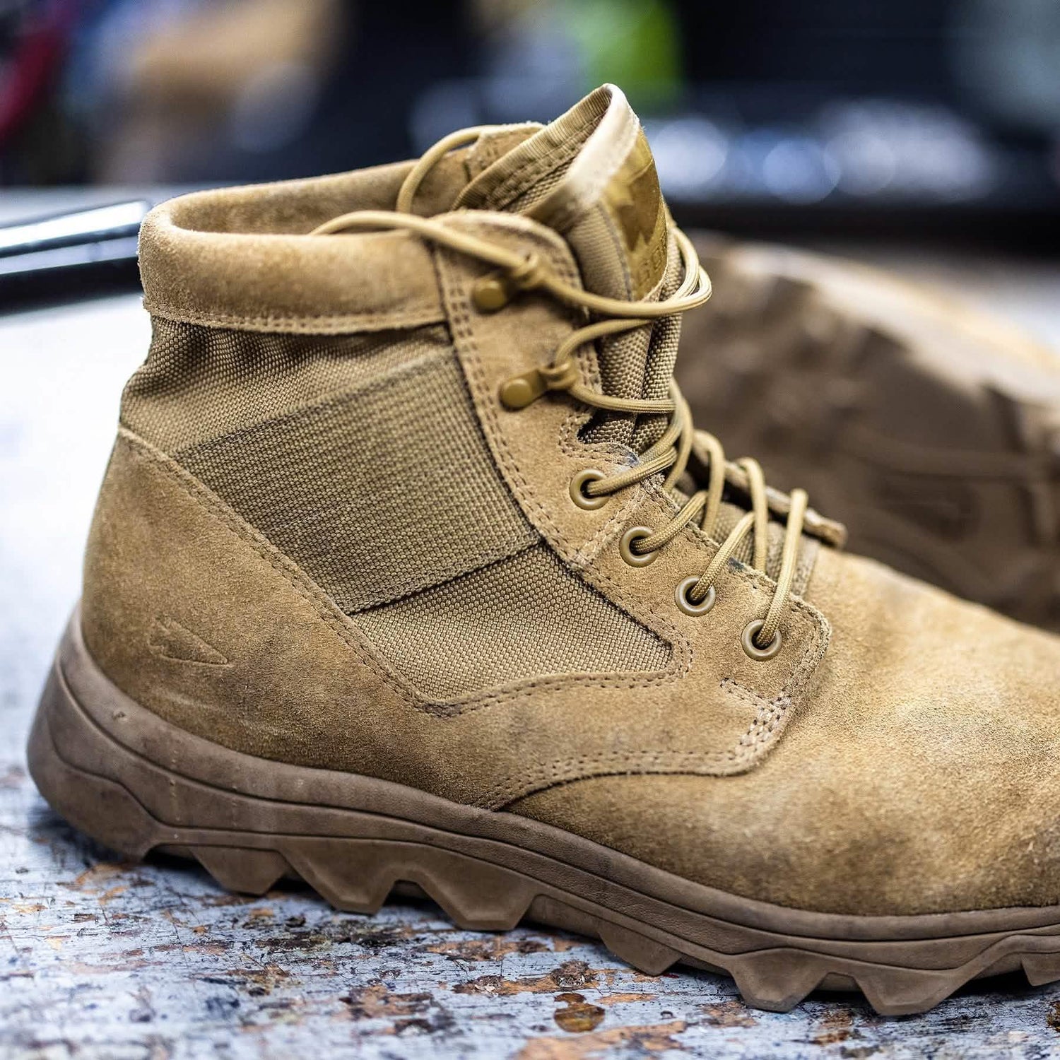 GORUCK tan rucking boot with rugged sole on a textured surface, close-up view