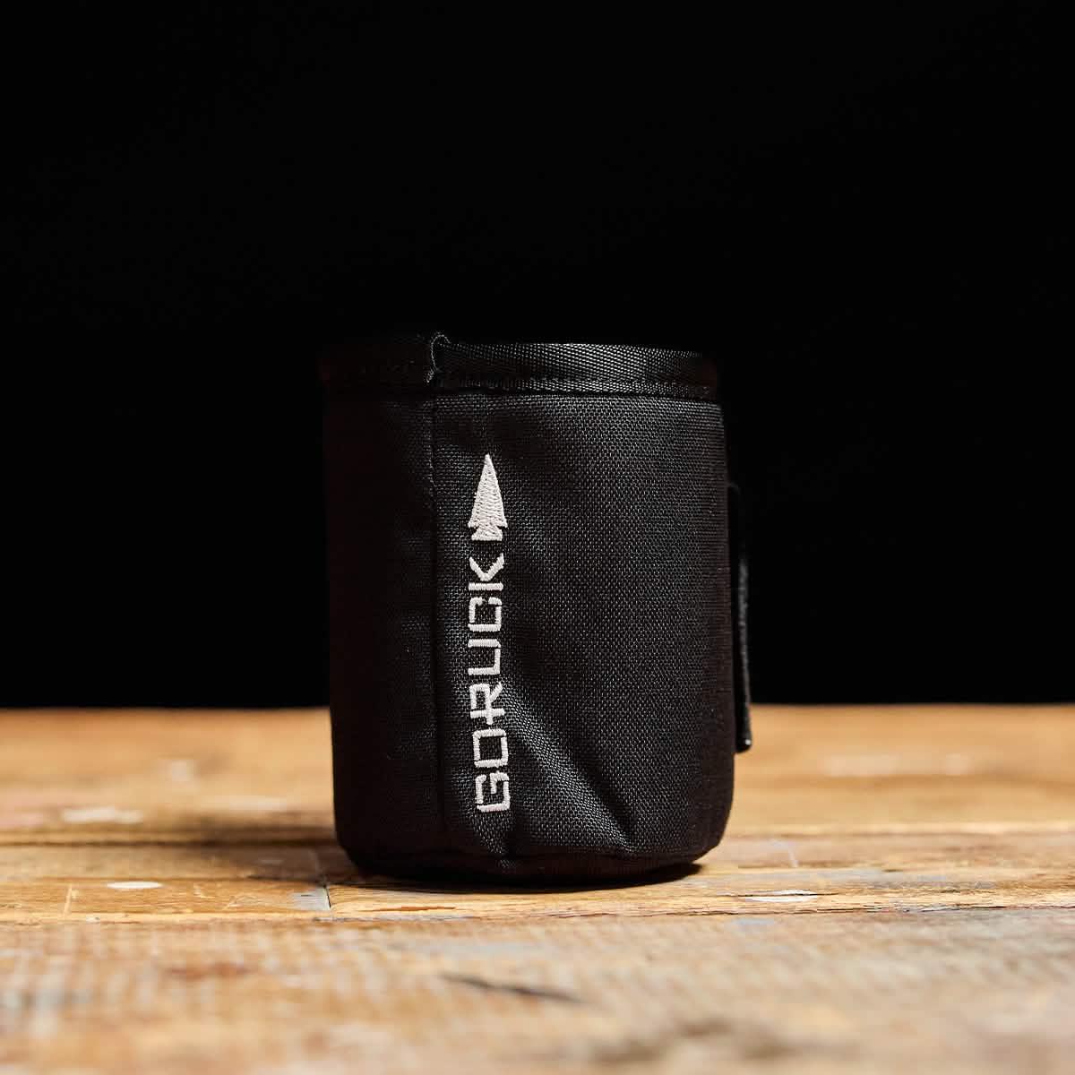 GORUCK black tactical beer jacket koozie on wooden surface, rucking gear accessory