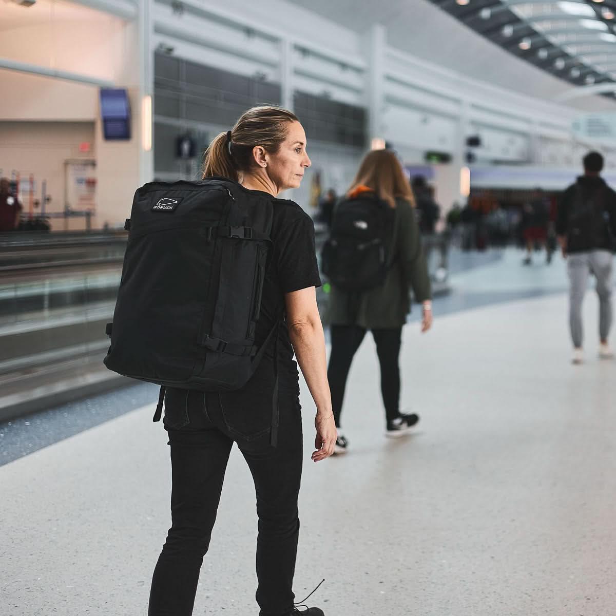 Woman wearing GORUCK backpack walking through airport terminal