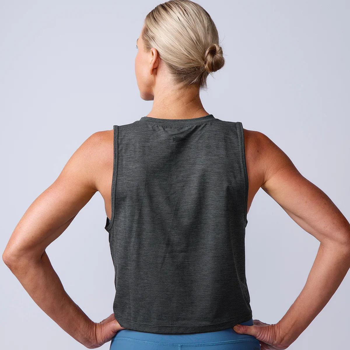 Woman wearing a dark sleeveless GORUCK training tank, shown from the back.