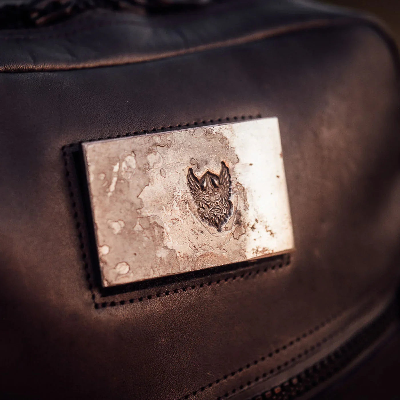 Close-up of GORUCK rucking backpack with rugged metal patch and engraved logo.