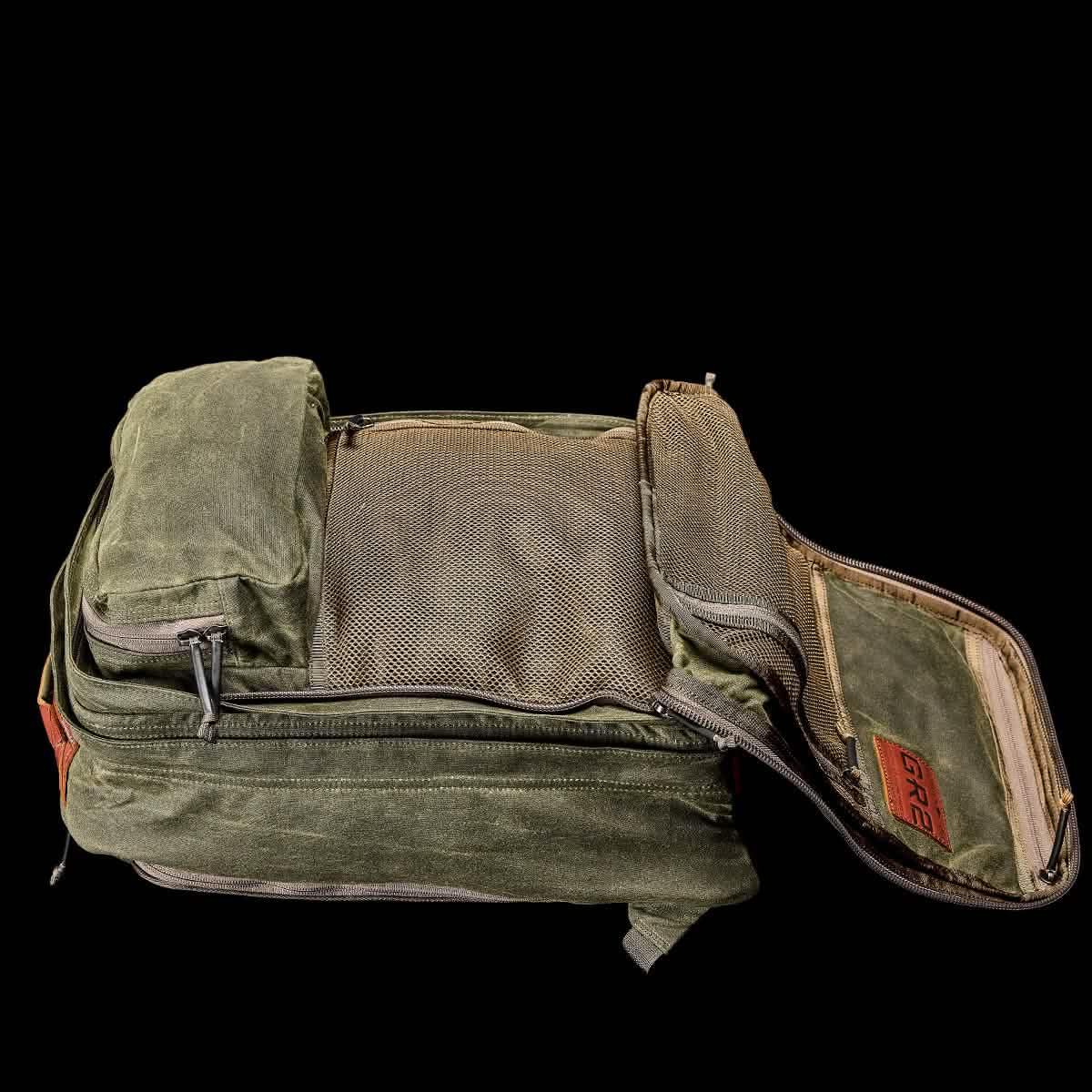 GORUCK olive green rucksack with multiple compartments and mesh pockets, open on black background