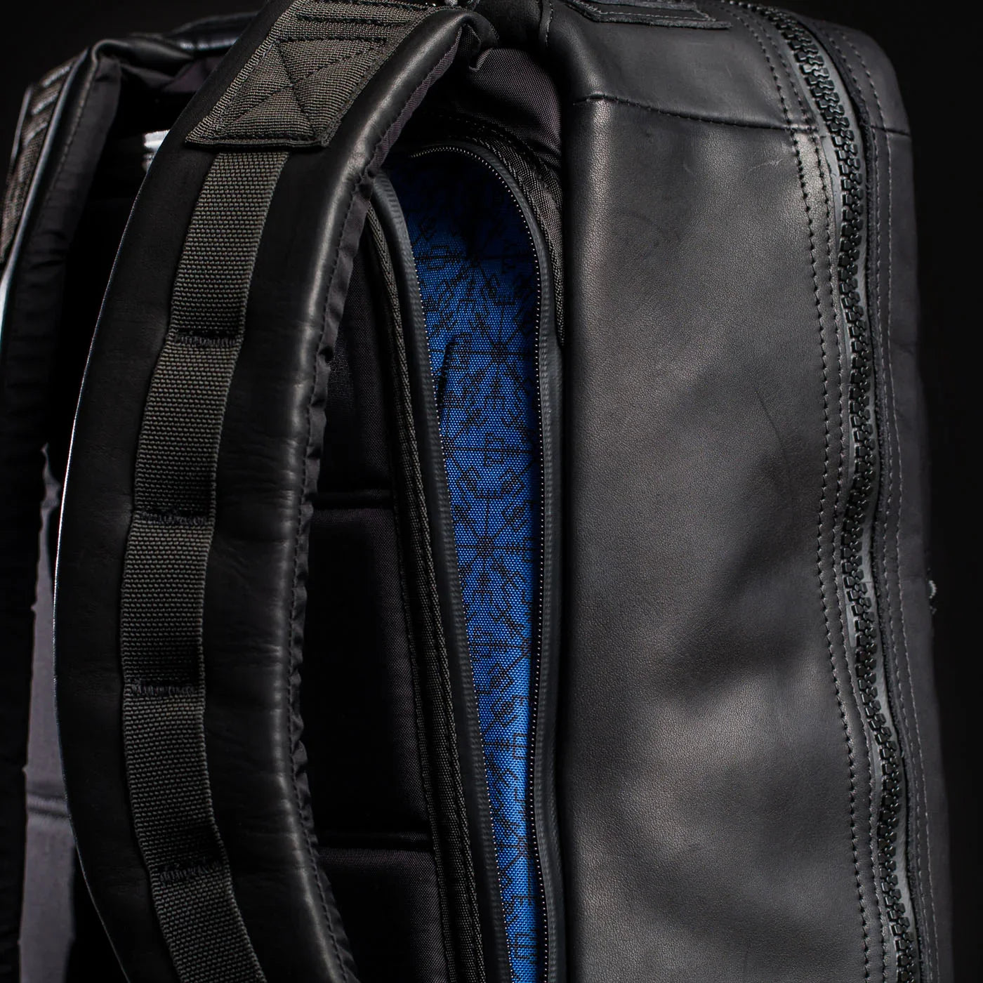 Close-up of GORUCK black leather backpack with padded straps and blue pattern lining
