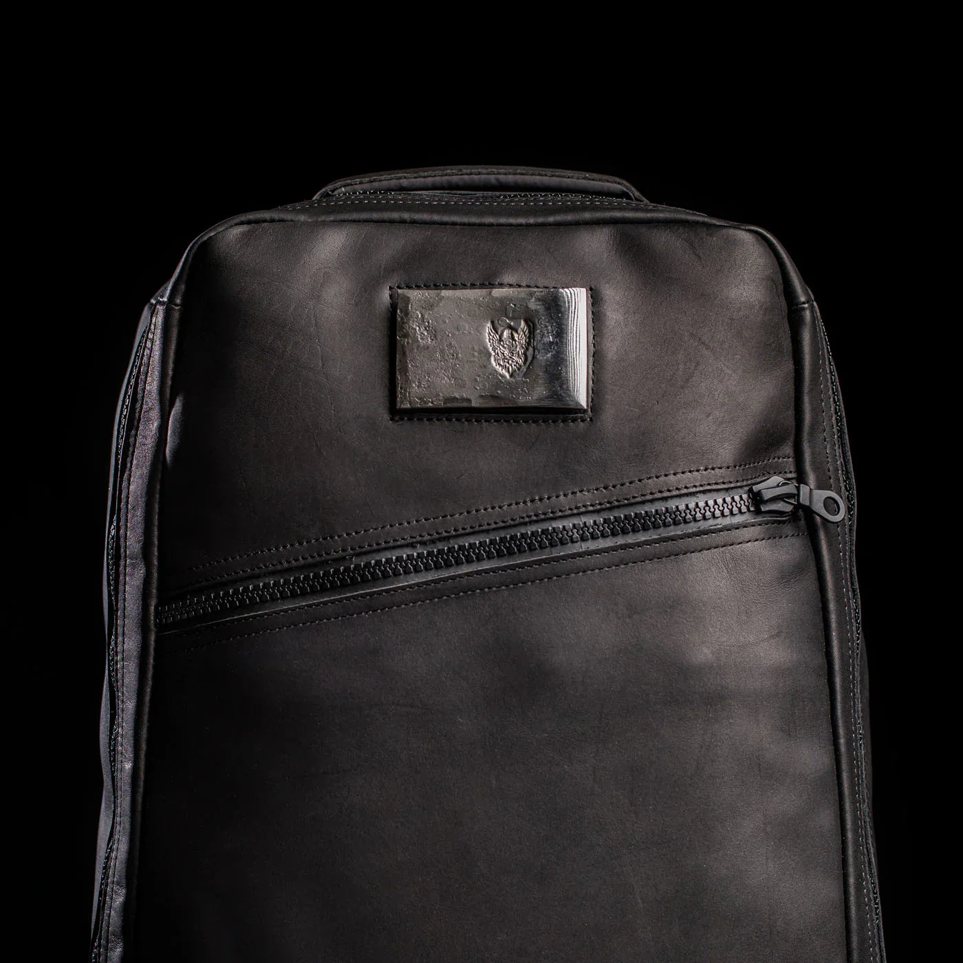 GORUCK black rucking backpack with angled zipper and patch on front, studio background