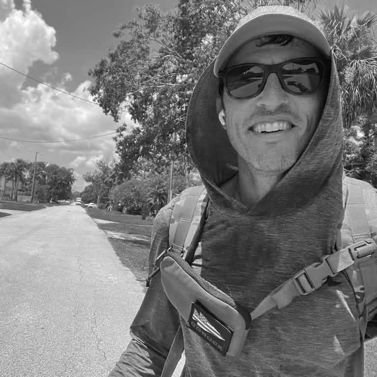 Person wearing GORUCK sternum strap pouch and backpack outdoors, black and white photo.