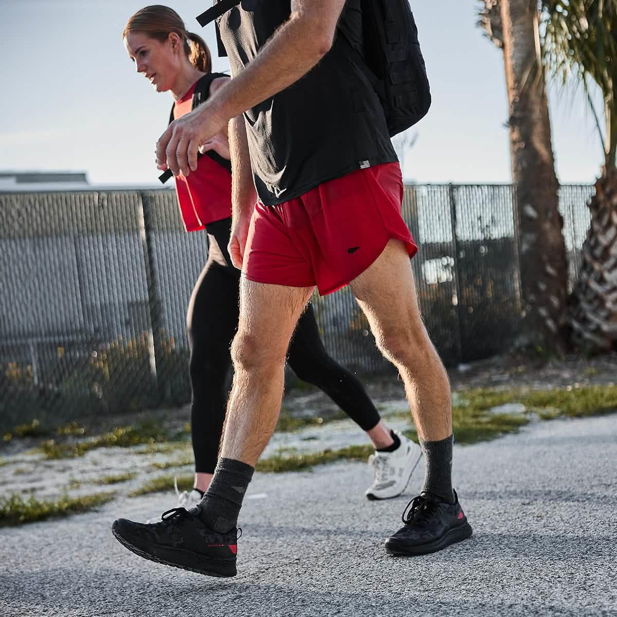 Two people rucking outdoors with GORUCK gear, wearing athletic apparel and backpacks