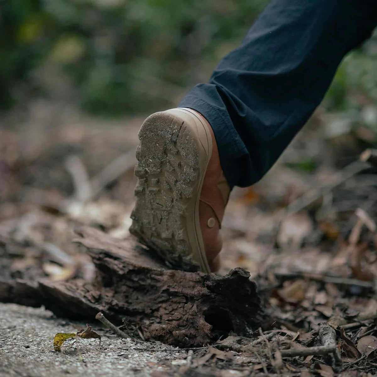 GORUCK brown MACV-2 Mid Top rucking boot on rugged outdoor trail with dirt and leaves