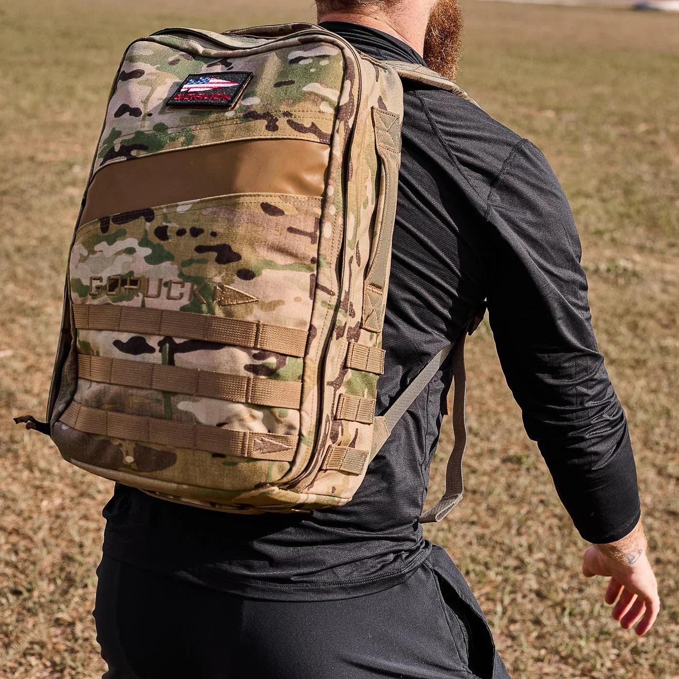 Man wearing black GORUCK long sleeve top with multicam ruck backpack outdoors