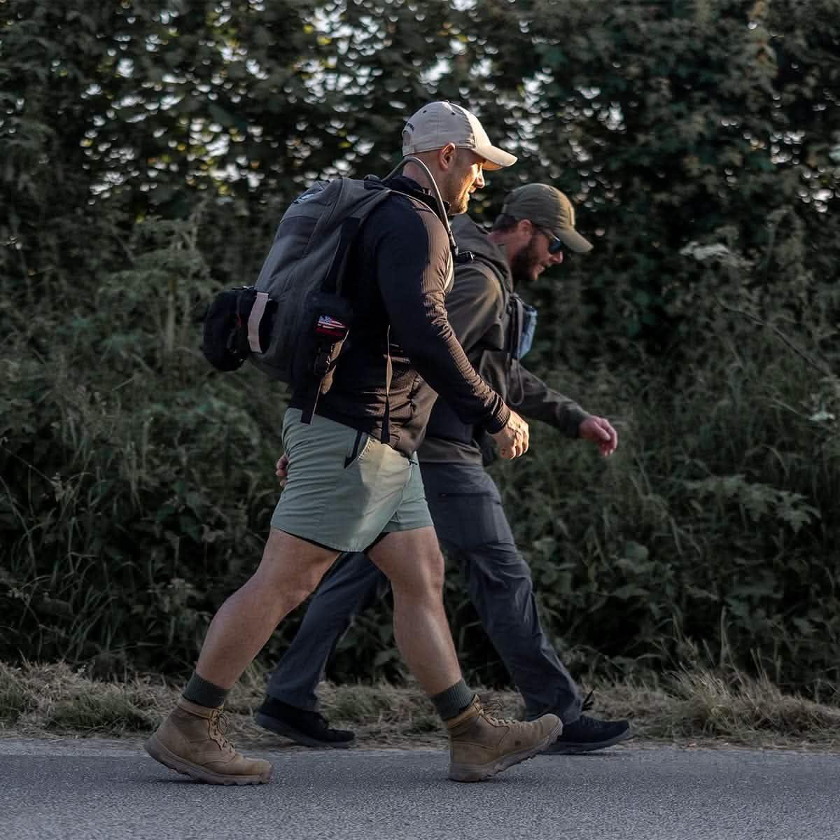 Two men rucking with backpacks wearing GORUCK boots and Merino wool socks outdoors