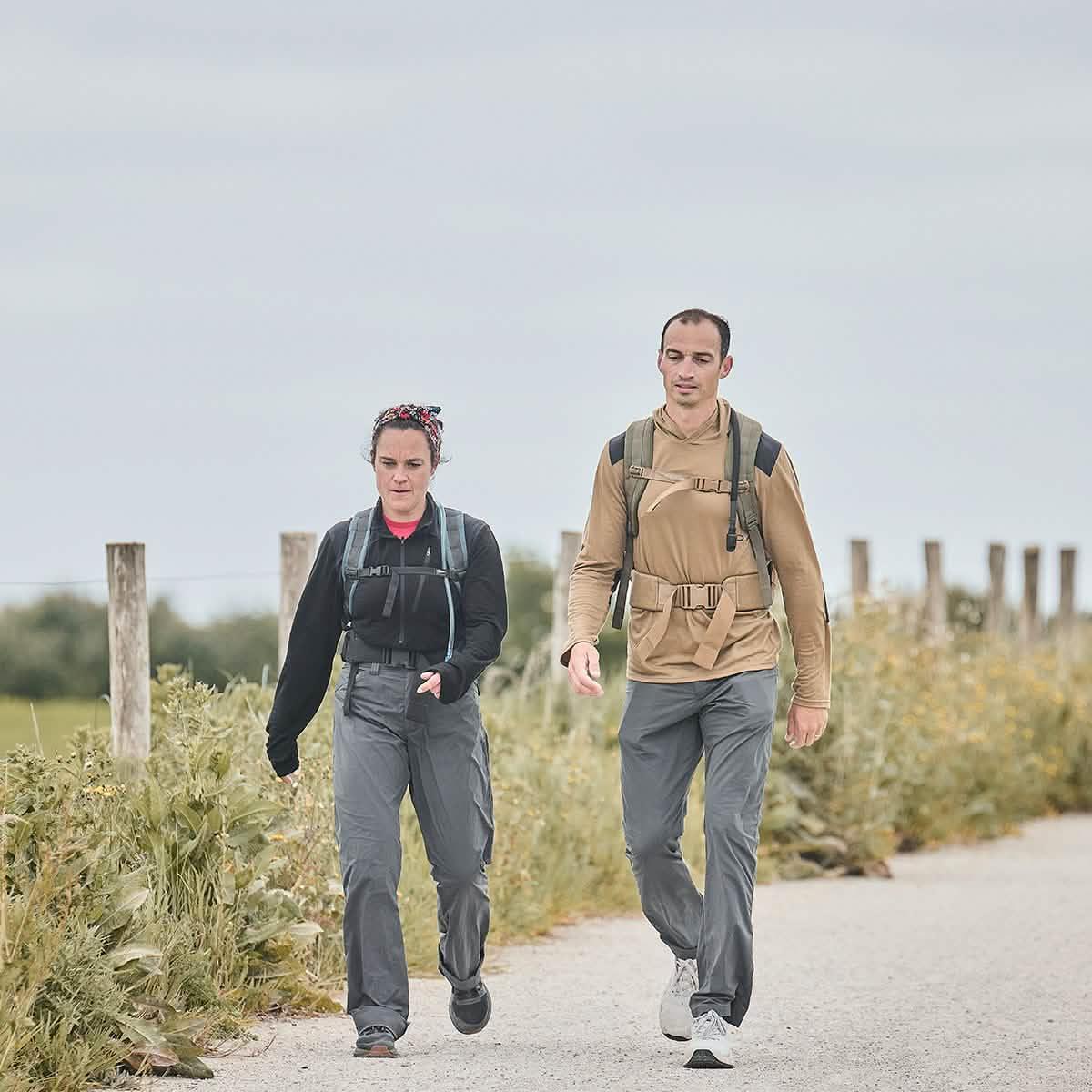Two people rucking outdoors in GORUCK gear with backpacks on a rural path