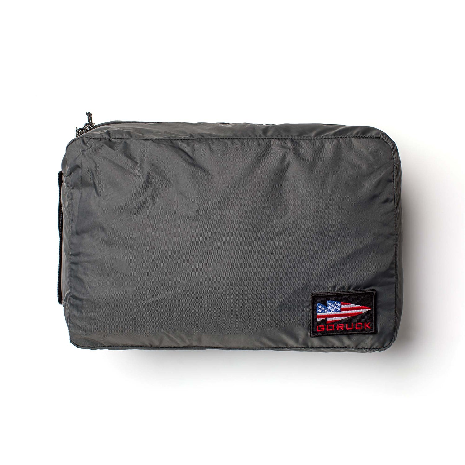 The Packing Cubes are gray zippered travel organizers made from durable 200D nylon, with a patch displaying an American flag and