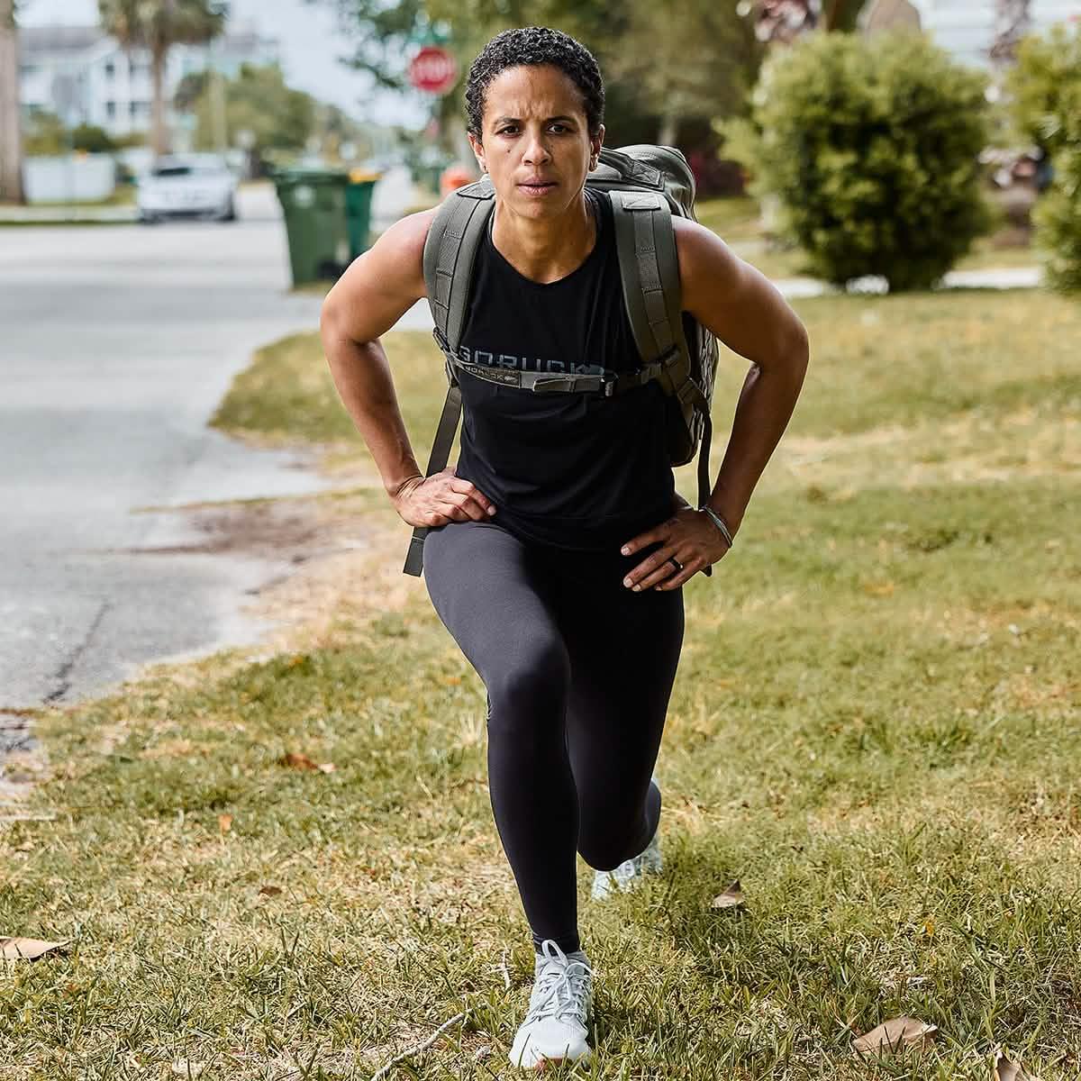 Person wearing GORUCK gear doing outdoor lunge exercise, training with a rucksack