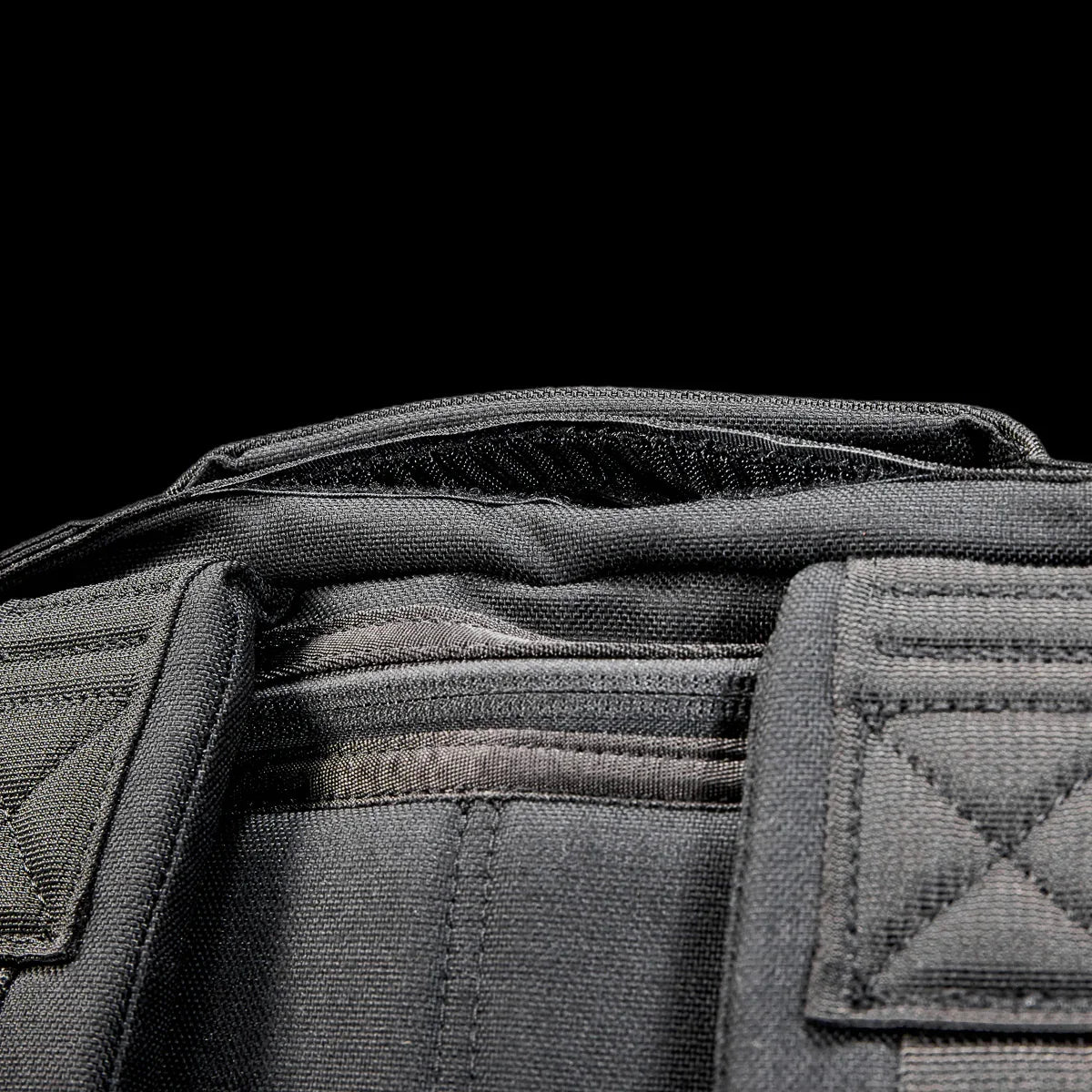 Close-up of GORUCK Radio Ruck black backpack top handle and rugged stitching detail