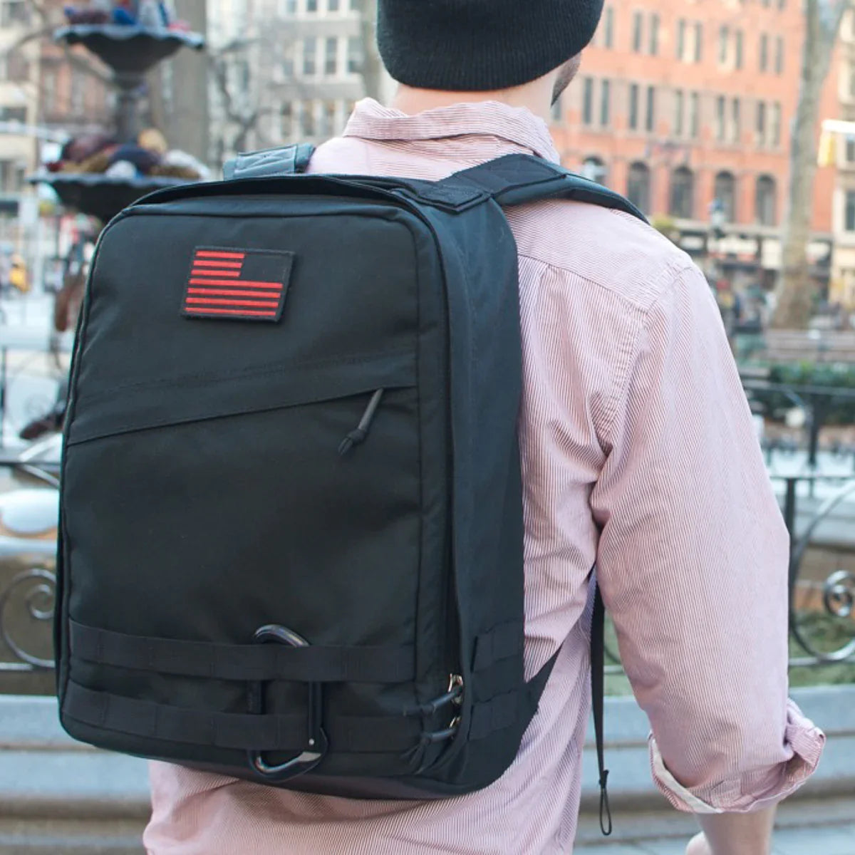 Man wearing GORUCK black Radio Ruck backpack with American flag patch outdoors