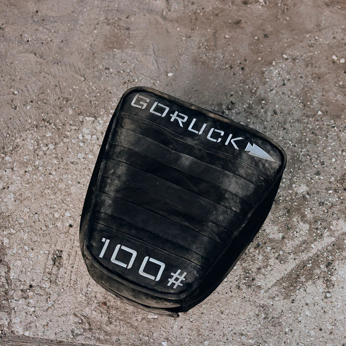 GORUCK 100-pound sand training weight on rough outdoor ground, durable rucking gear