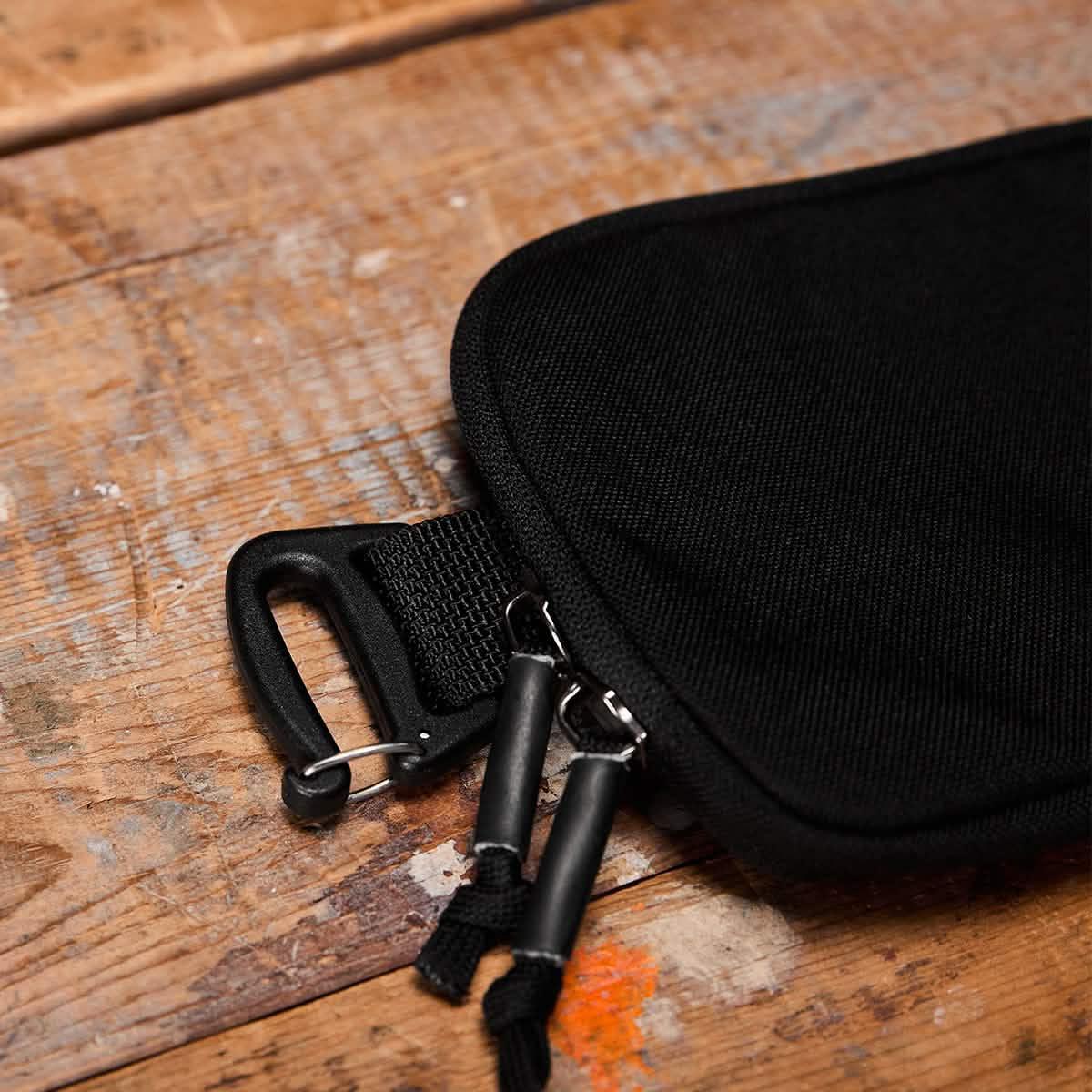 GORUCK black sternum pouch with zipper and clip on rustic wooden surface