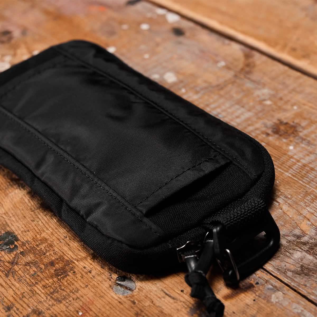 GORUCK black sternum pouch on rustic wooden surface, rugged rucking gear accessory
