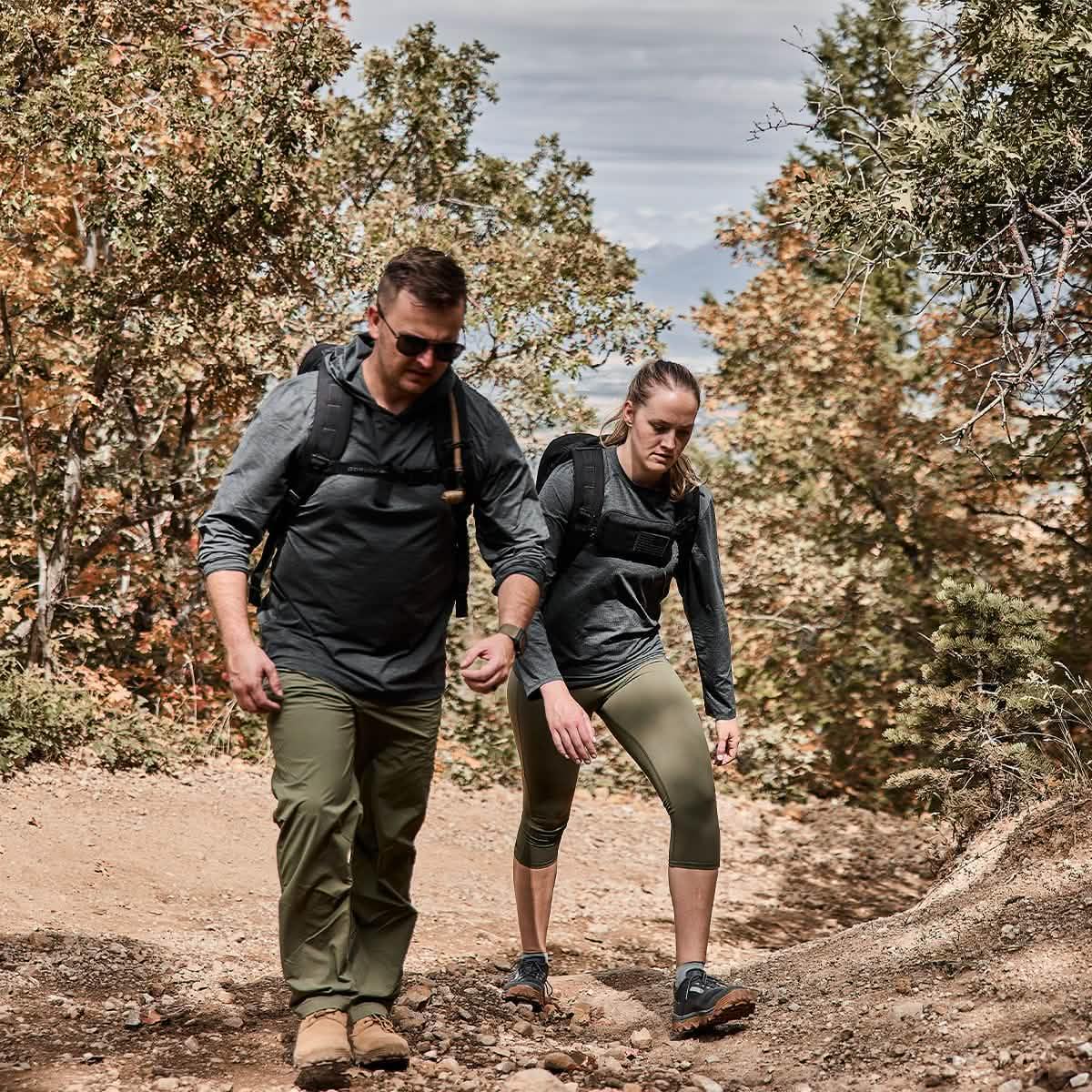 Man and woman rucking on a rugged trail in GORUCK gear with backpacks outdoors