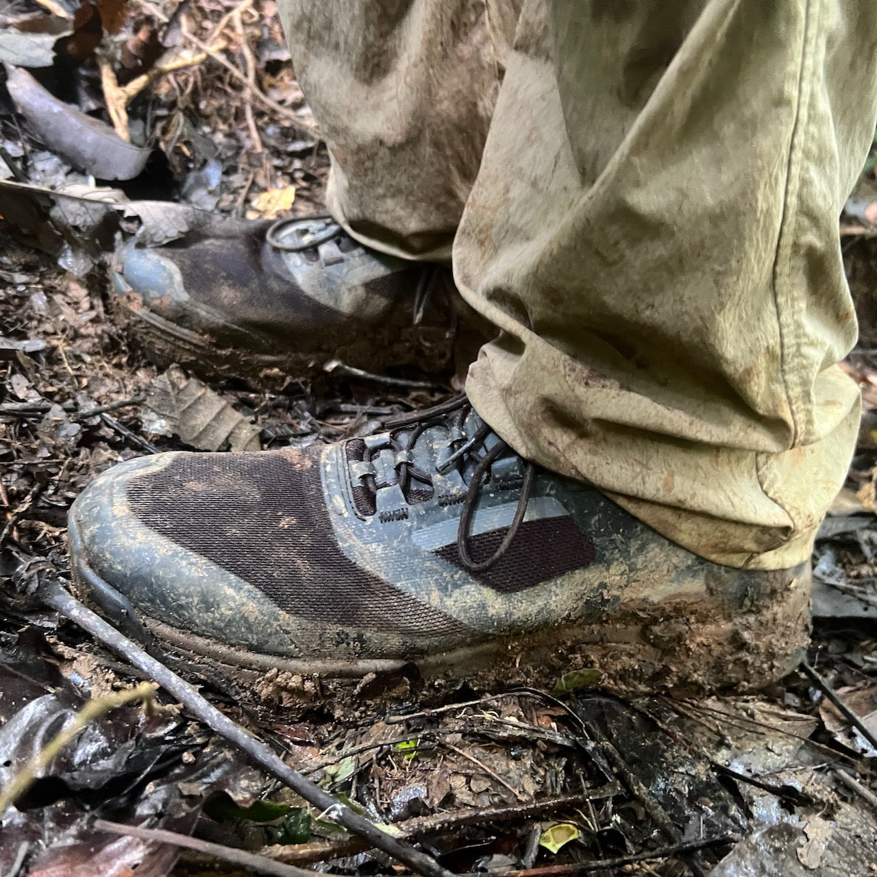 Trek down a forest trail covered with wet leaves and soil in the Mackall - Black + Forged Iron all-terrain hiking boots and pants.