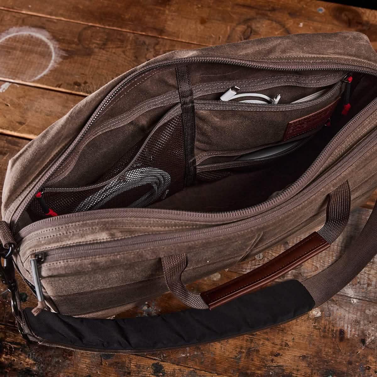 GORUCK brown tactical rucking laptop bag open on rustic wood table, showing organized compartments