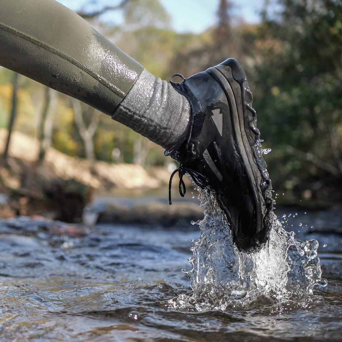 GORUCK rucking shoe and grey sock splashing in outdoor stream, rugged trail gear