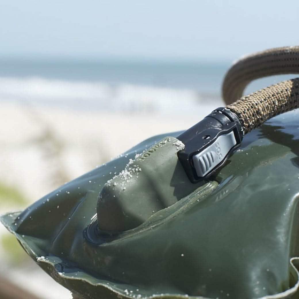 GORUCK hydration bladder with sand on nozzle and hose at a beach
