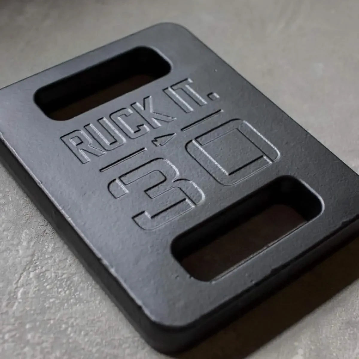 GORUCK 30lb ruck plate close-up, black weight with cutout handles on concrete