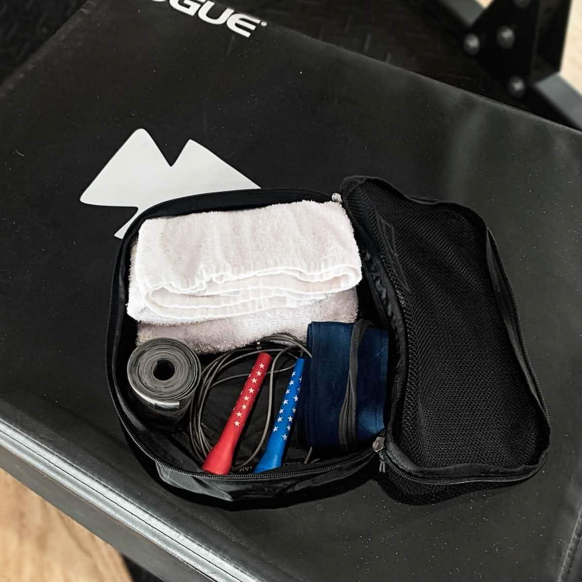 GORUCK 5L packing cube with gym towel, jump rope, and resistance band on gym bench