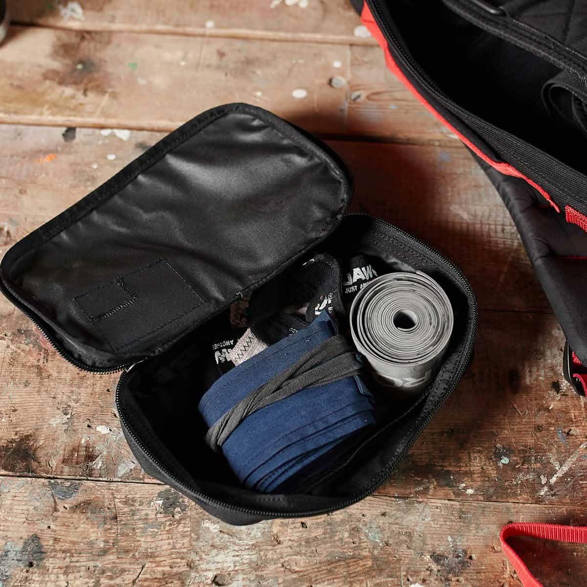 GORUCK Shadow Pocket M gym gear pouch open on rustic table with organized fitness accessories