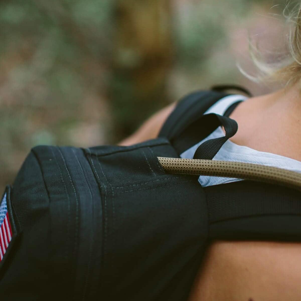 GORUCK rucking backpack with hydration hose and American flag patch outdoors