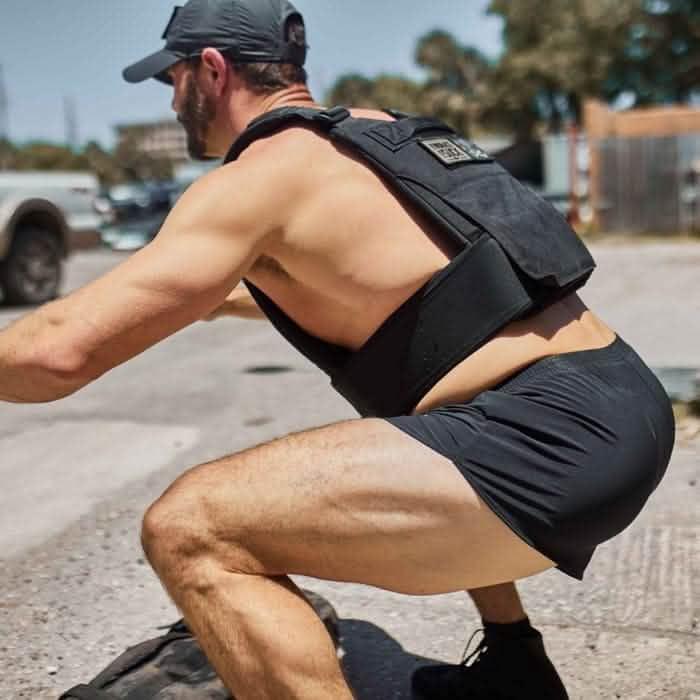 Man wearing GORUCK weighted vest performing outdoor squat exercise