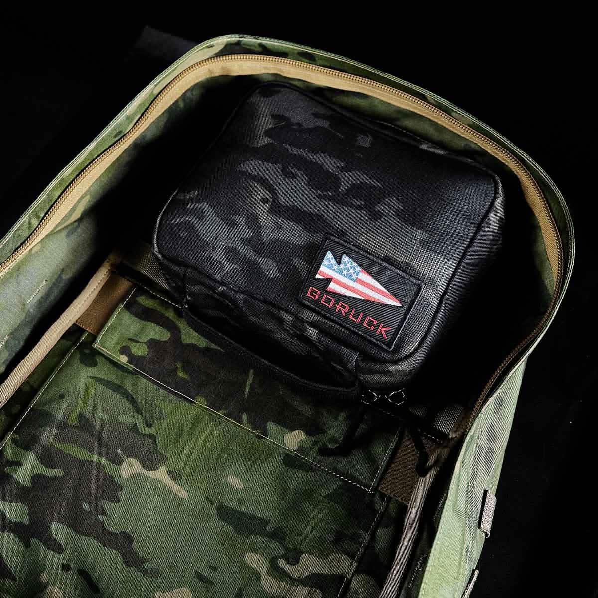 GORUCK rucking backpack with camouflage interior and black GORUCK pouch featuring USA flag patch