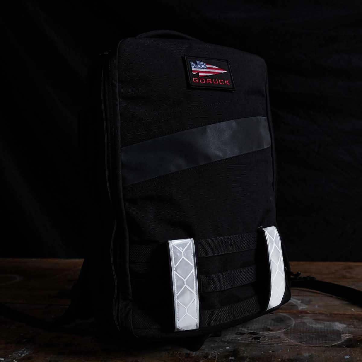 GORUCK black rucksack with reflective strips and American flag patch on dark background