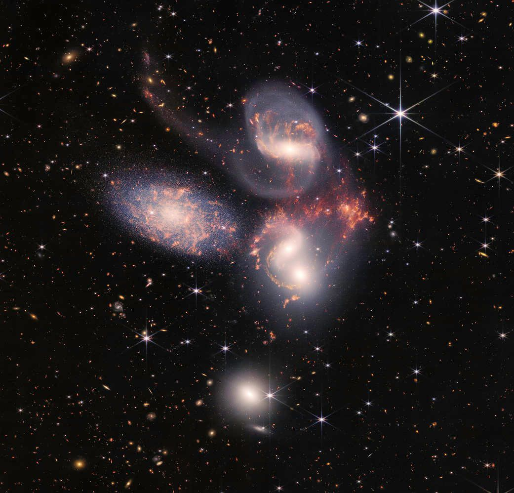 Colorful galaxy cluster and stars in deep space against a black cosmic background.