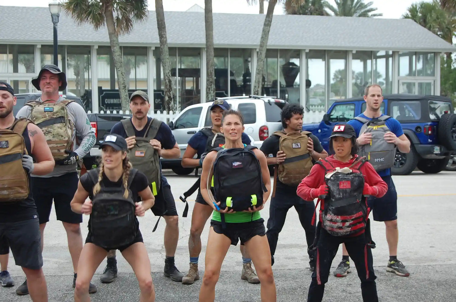 Group of people doing outdoor rucking exercise with GORUCK backpacks in a parking lot