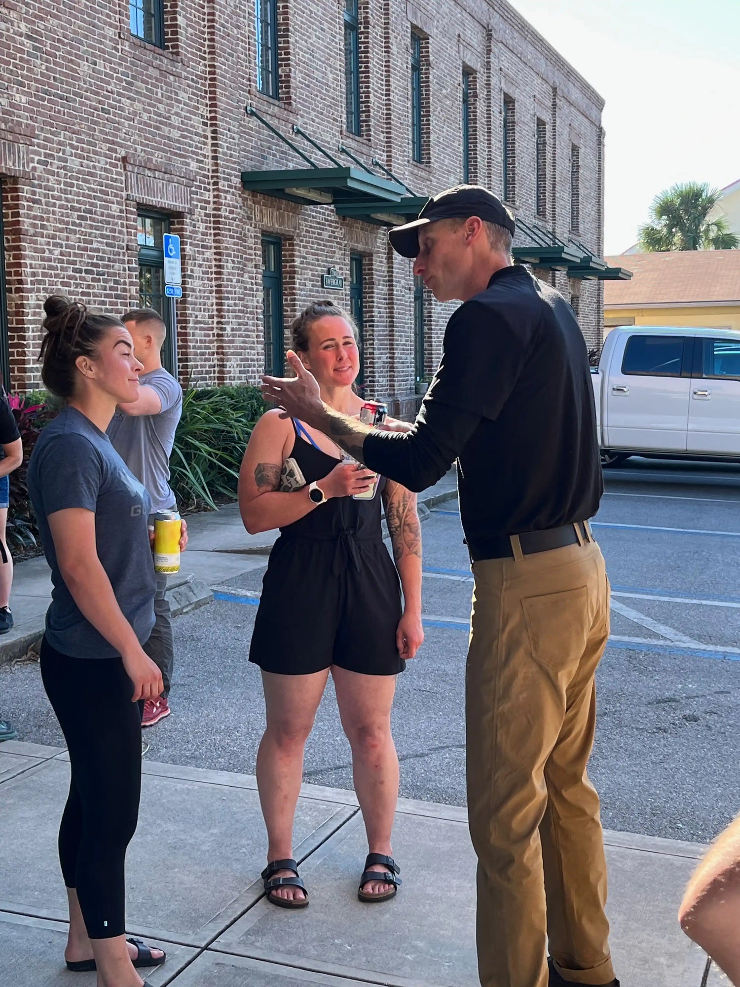 GORUCK team members in casual conversation outside brick building, community rucking event