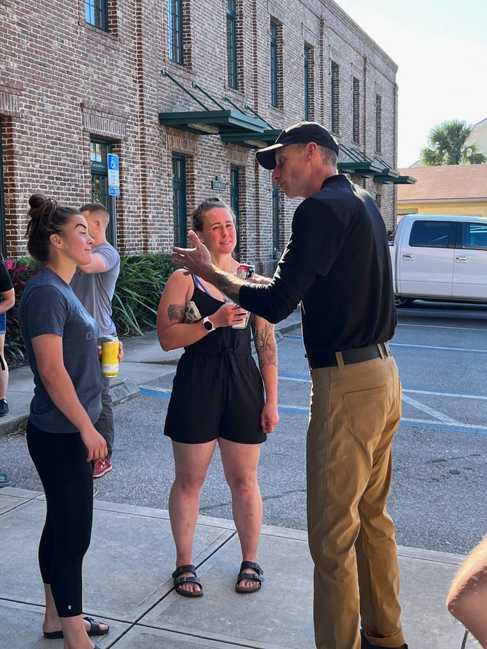 GORUCK team members in casual conversation outside brick building, community rucking event