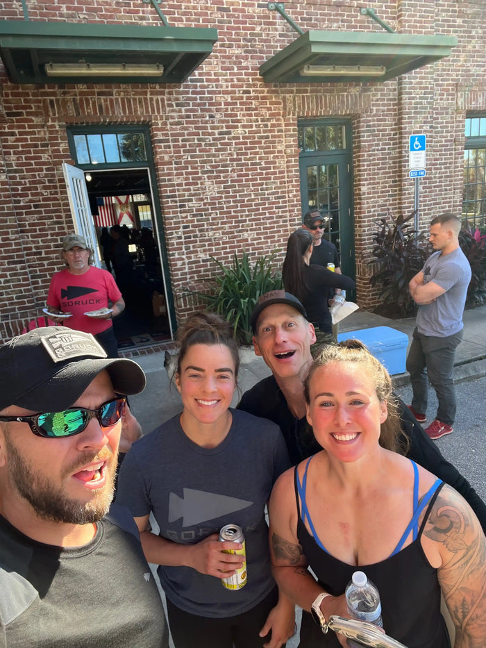 GORUCK team members smiling outside brick building during rucking event