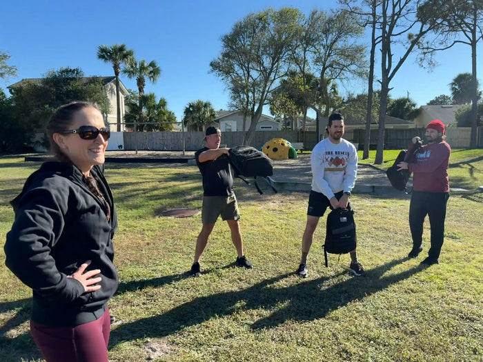 Group rucking workout outdoors with GORUCK gear on a sunny day, smiling participants
