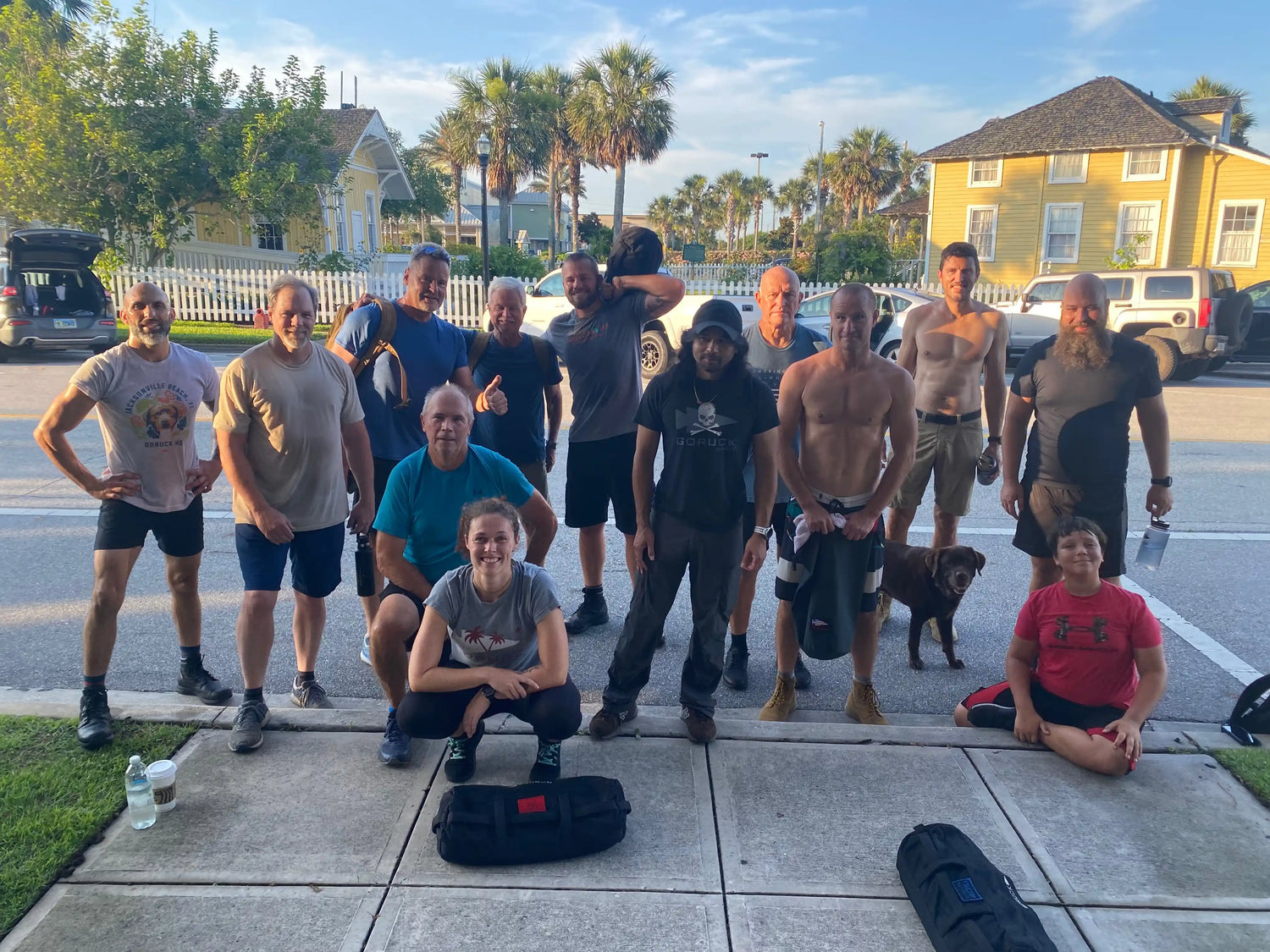 GORUCK group workout outdoors with rucking gear, men and women posing on sidewalk