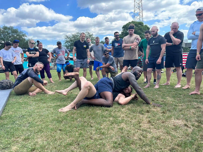 Group of people watching outdoor grappling demonstration at GORUCK rucking event