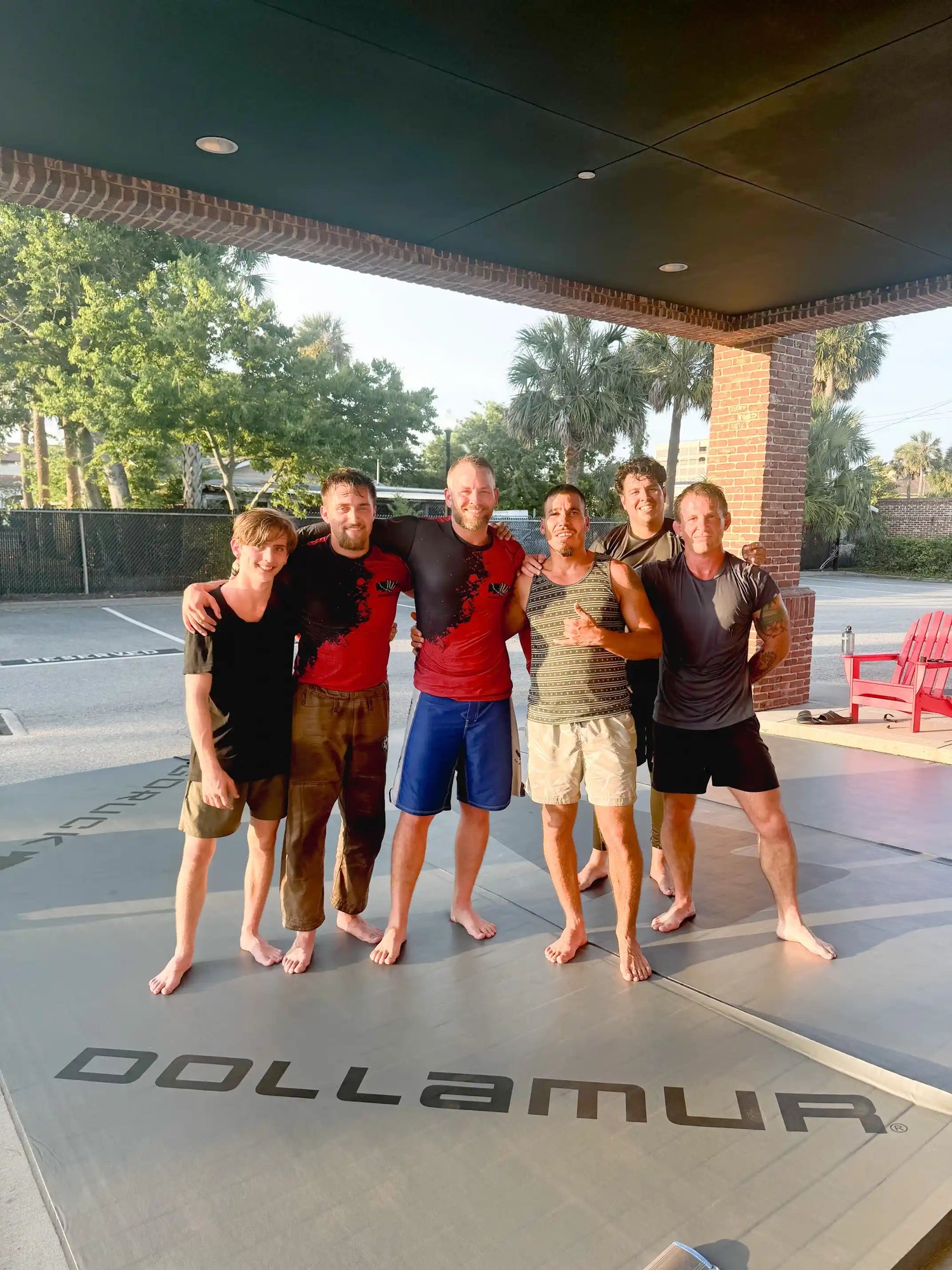 Group of men barefoot on outdoor training mat, GORUCK fitness community event