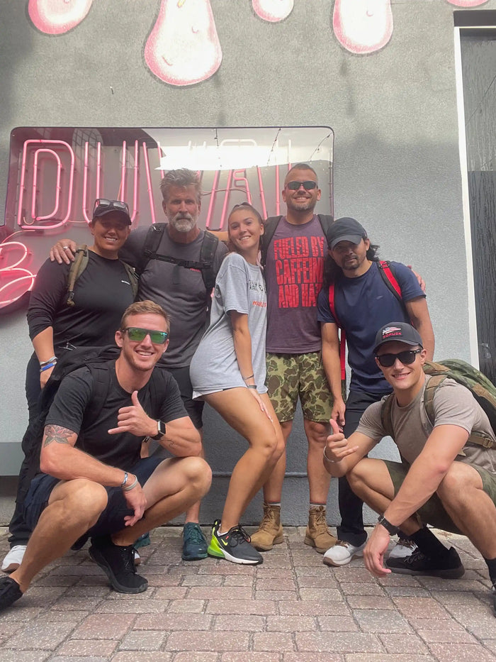 Group of GORUCK rucking enthusiasts posing outdoors in athletic gear and backpacks